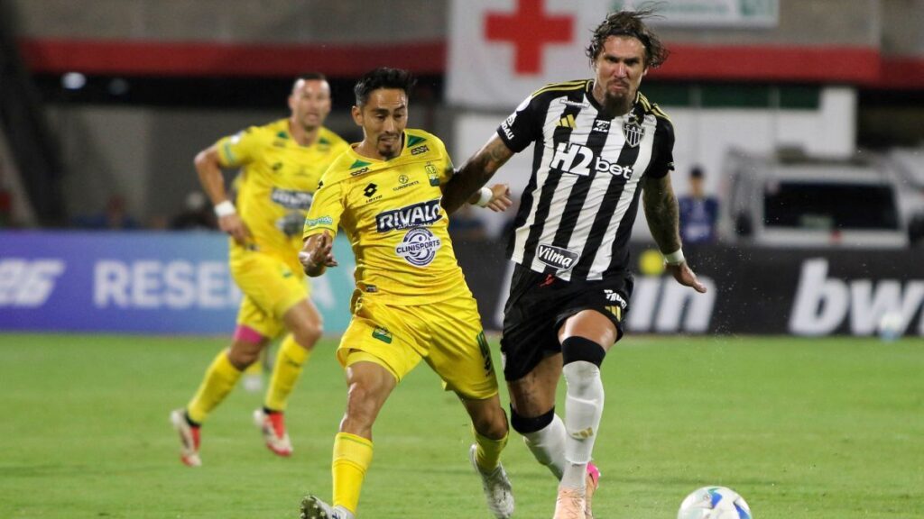 Fabián Sambueza y Gustavo Scarpa disputan la pelota. - AFP.