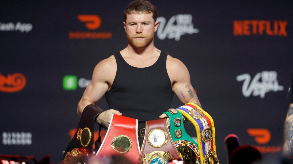 Canelo posando con sus cinturones de campeón