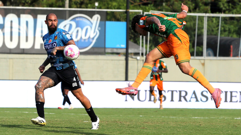 Santiago Londoño hace un remate de cabeza ante Quintero. | VizzorImage