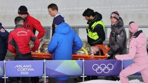 Piloto de bobsleigh sale en camilla tras aparatoso accidente en Milano Cortina