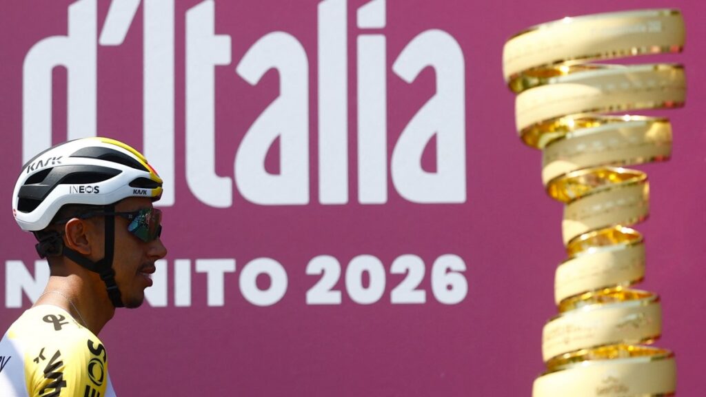 Egan Bernal pasando al lado del trofeo del Giro de Italia