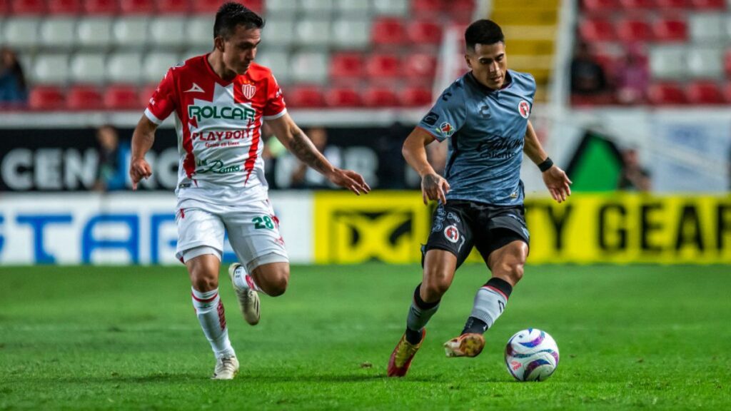 Jugadores de Tijuana y Necaxa disputan el balón en juego de futbol