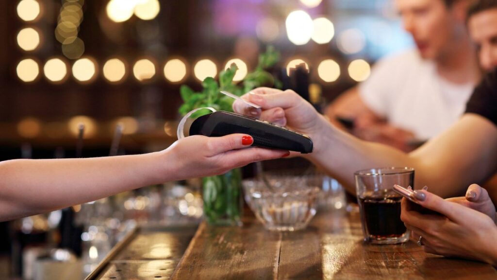 Mesero cobrando en un bar