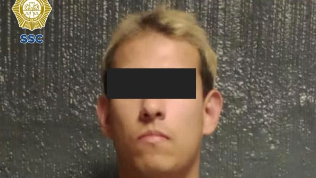 Ficha de autoridades con el rostro de un hombre de pelo rubio con los ojos cubiertos por una cintilla negra