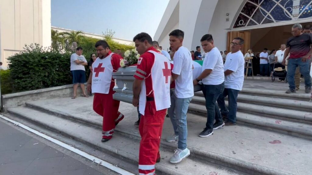 Excompañeros de la Cruz Roja, del marino, cargan su féretro.