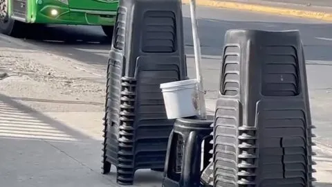 Luis Esteban presta banquitos mientras esperan el camión en Guadalajara