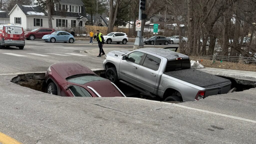 Esperaban el semáforo y 2 vehículos caen en socavón abierto repentinamente en Estados Unidos