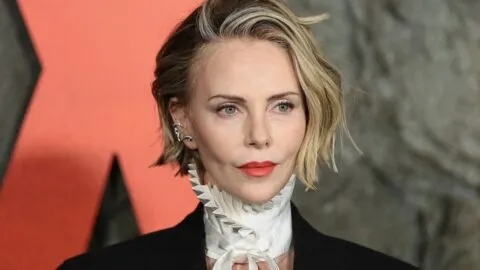 Charlize Theron sorprende al escalar enorme muro de roca en Times Square para promocionar su nueva película, “Apex”