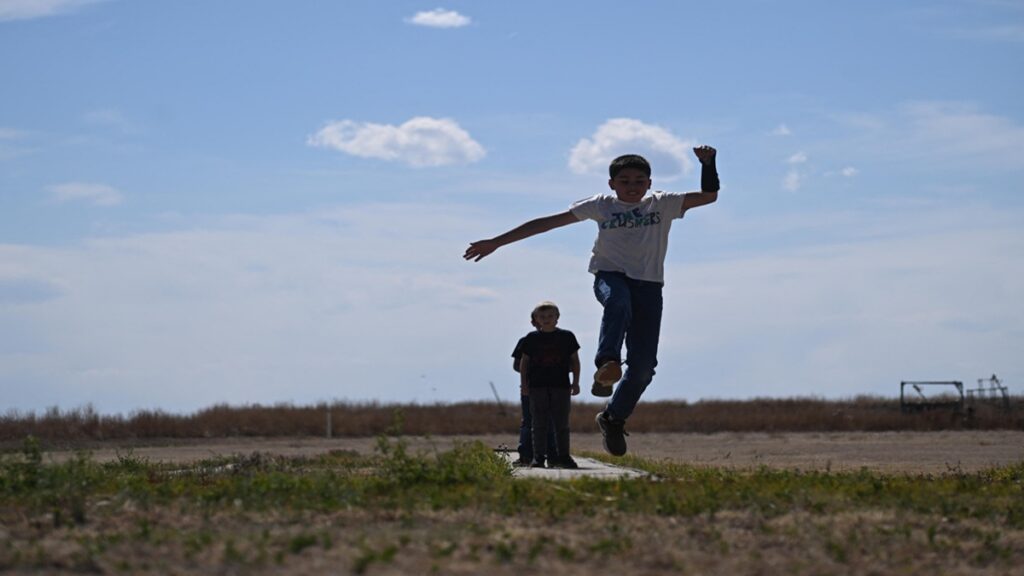 Niños de Estados Unidos corren por un campo