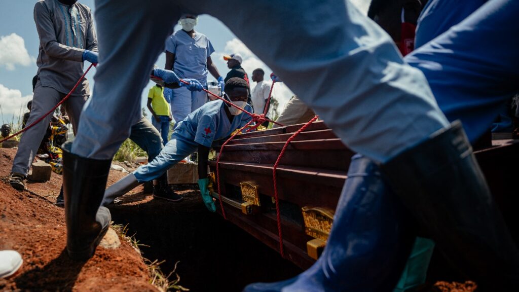 Miembros de un equipo de la Cruz Roja bajan el ataúd de mujer que falleció por el virus del ébola en el Congo. Foto: AFP