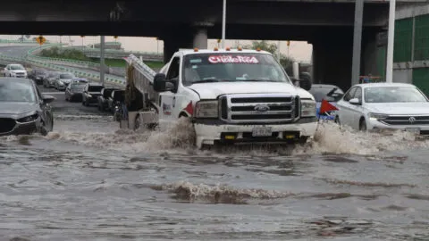 Pasajeros de microbús se arriesgan para rescatar a motociclista arrastrada por inundaciones en la Vía Morelos