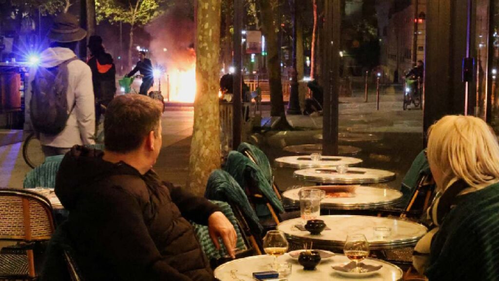 VIDEO: Pareja bebe vino mientras observa las violentas protestas en París, Francia